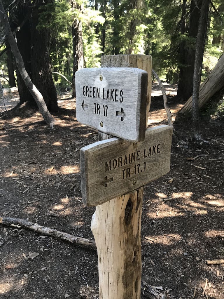 Two Weathered Wooden Trail Signs Stand in a Sun Dappled Forest Guiding Hikers on Green Lakes Tr 17 and Moraine Lake Tr 17 Surrounded by Pines This Spot Marks One of the Classic Bend Hikes for Those Exploring Trails Near Bend Oregon