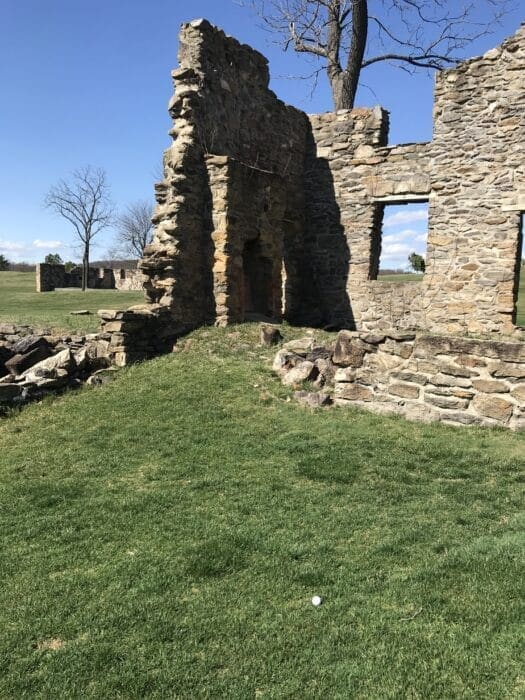 Partially Collapsed Stone Building Ruins Stand on a Grassy Field Under a Blue Md Sky the Structure Has Jagged Edges Missing Roof and Large Open Windows Leafless Trees Grow Behind the Building with Another Ruin Visible Near Golf Courses Near Frederick
