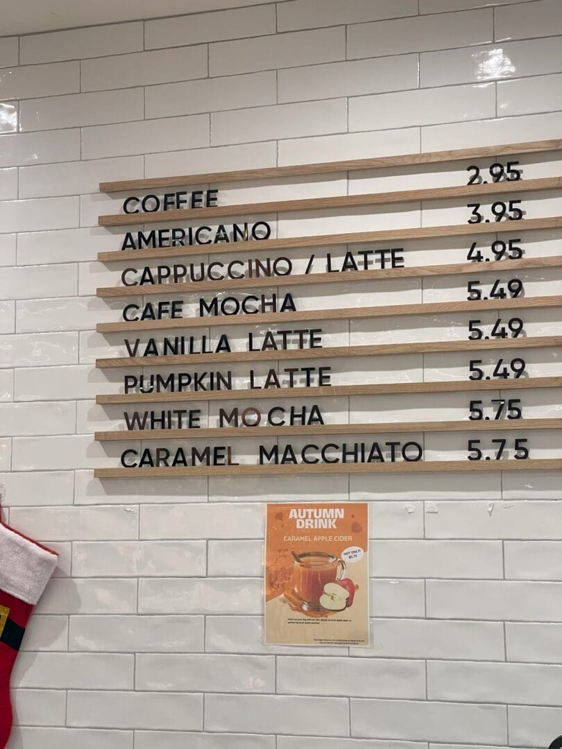 Juno bakery menu a Coffee Shop in Frederick Md Displays Its Menu on a White Tiled Wall Listing Drinks Like Americano Cappuccino Vanilla Latte Pumpkin Latte and Caramel Macchiato a Poster Highlights Their Caramel Apple Cider Autumn Drink