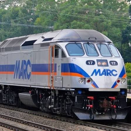 Front View of a Marc Diesel Locomotive on Railroad Tracks Gray with Blue and Orange Stripes and the Marc Logo Number 17 Visible